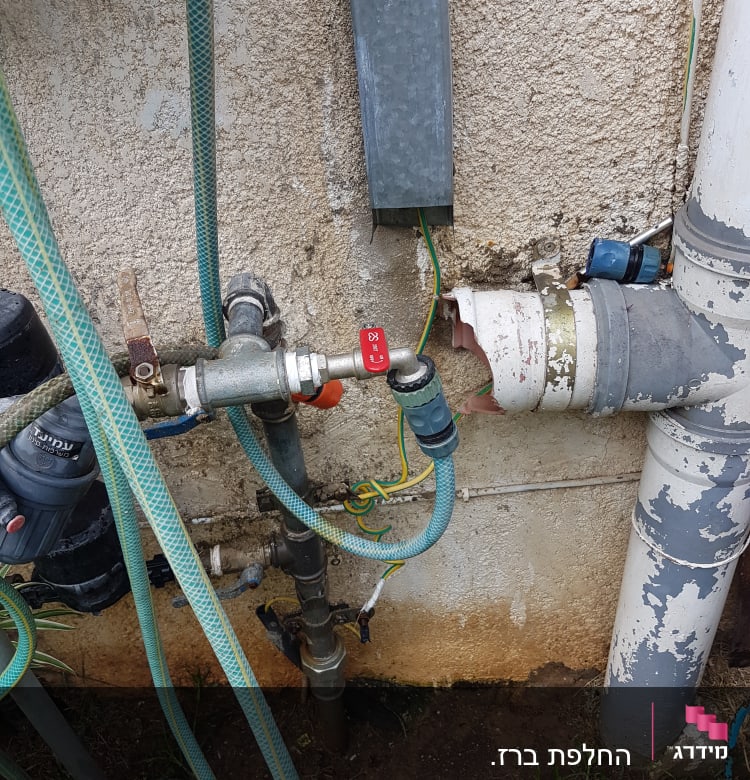 צינורות מים וברזים מחוברים לקיר חיצוני